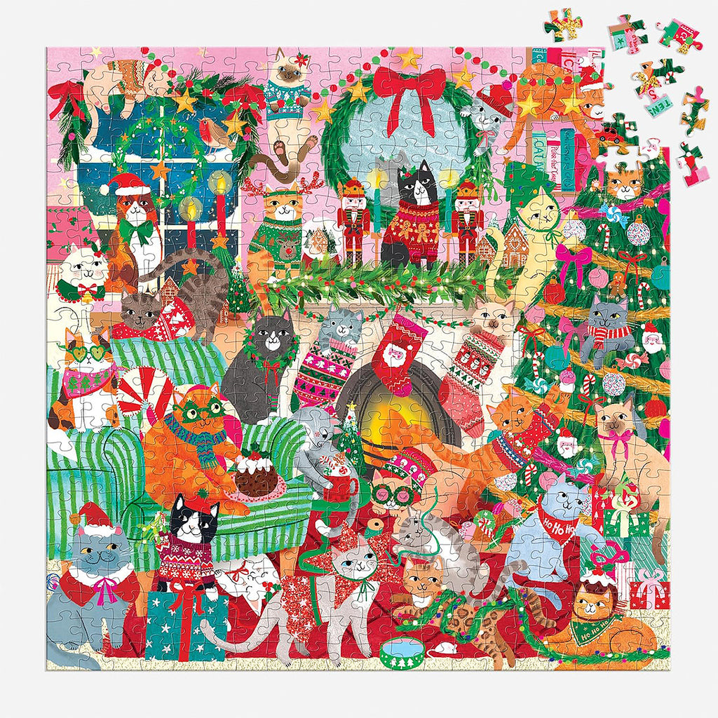 The completed Rebecca Jones Merry Catmas jigsaw puzzle displayed next to a scattering of loose puzzle pieces and the product box, showing the full scope of the 500-piece set.
