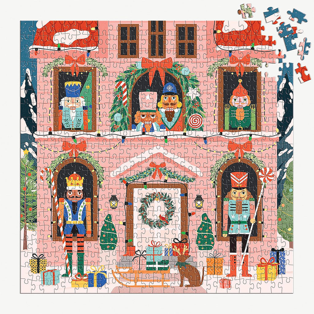 Close up of the scattered pieces of the Nutcracker Magic holiday jigsaw puzzle, with the completed image in the background, perfect for a Christmas activity.